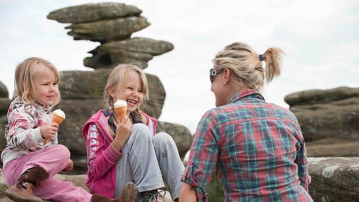 Two girls eating ice cream with a woman at Brimham Rocks